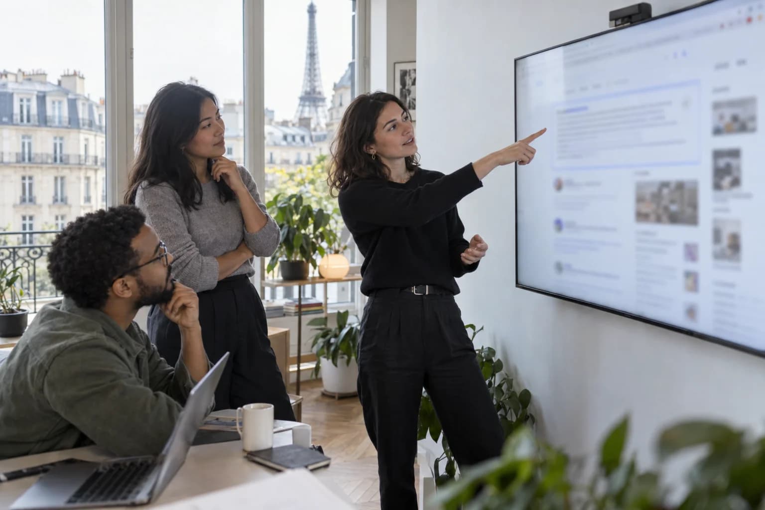 Équipe marketing dans un bureau parisien analysant une page de résultats de recherche affichée sur un grand écran